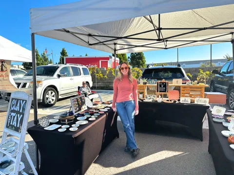 A local maker sharing handmade goods at her market stall